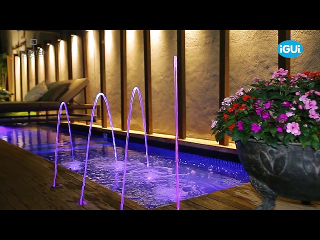 Piscina retangular em residencia com jatos de água iluminados