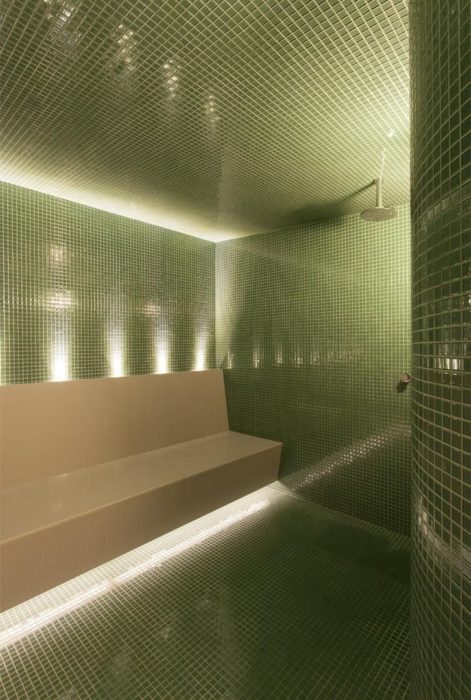 Interior de sauna úmida com acabamento em pastilhas verdes