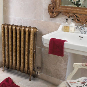 Radiador de calefação metálico dourado em banheiro